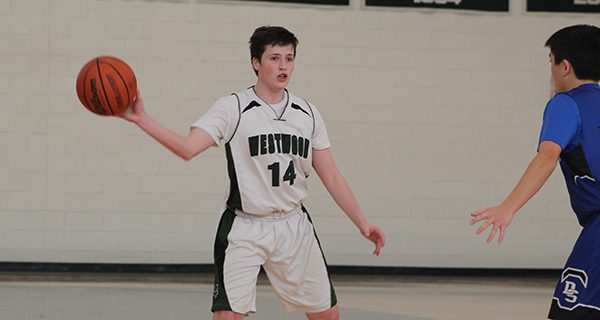 Sophomore guard James McGowan (14) distributes a one-handed pass during Westwood’s 67-65 victory over Dover-Sherborn on Monday. Photos by Michael Flanagan