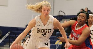 Sophomore guard/forward Caroline Klemm (12) fights off a defender and drives the ball to the basket.