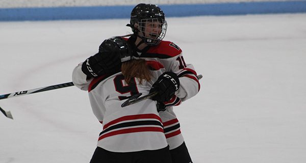 Lauren Burke (18) celebrates with teammate Maja Desmond (9) following her game-tying goal late in the second period of Monday night’s 2-2 tie with Notre Dame Academy. Photos by Michael Flanagan