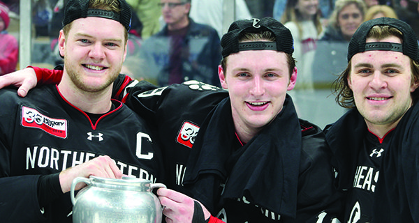 From left-to-right: Eric Williams (C), Walpole native Lincoln Griffin (19), and Canton native Liam Pecararo pose together with the Beanpot trophy after helping Northeastern to its second consecutive and sixth-ever Beanpot championship on Monday night at TD Garden with a 4-2 win over Boston College.