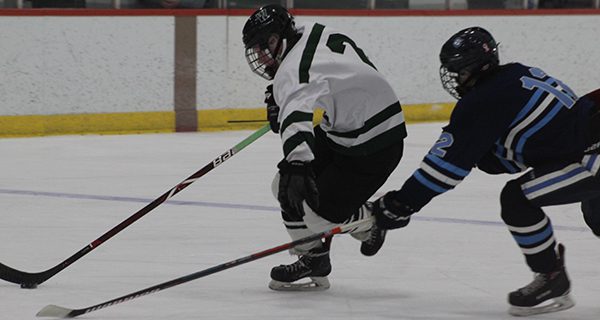 Conor Donohue (pictured) fights off a poke check and moves the puck into the attacking zone. Photos by Michael Flanagan