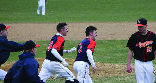 The Rebels erupt from the dugout to celebrate their 1-0 walk-off victory as Newton North’s pitcher leaves the field. Photos by James Kinneen