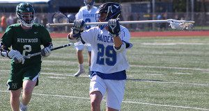 Dover-Sherborn’s Cam Raycroft (29) moves the ball up field on a clear with Westwood’s Conor Donohue (2) hot in pursuit on the ride.