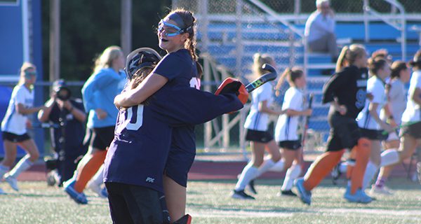 Goalie Cammie Foster (50) and defender Lilly Callahan (25) celebrate following Needham field hockey’s 1-0 victory over Dover-Sherborn on Monday.