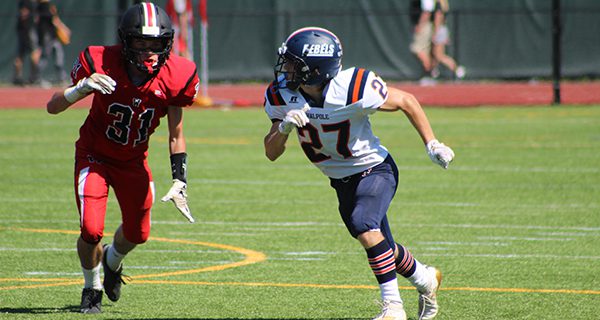 Walpole’s Derek Petrucci (27) gets off his block from Wellesley’s Grady Cook (31) and rushes down the field on punt coverage. Photos by Mike Flanagan