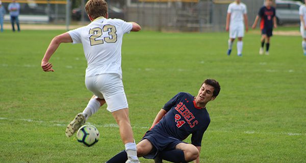 Walpole’s Daniel Gourdoukis (24) performs a slide tackle on Needham’s Steven Donovan (23) early in the first half.