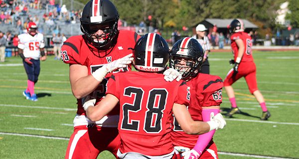 Holt Fletcher (53) and Anthony Cristoforo (62) celebrate with teammate Matt Segel (28) following a second quarter touchdown.