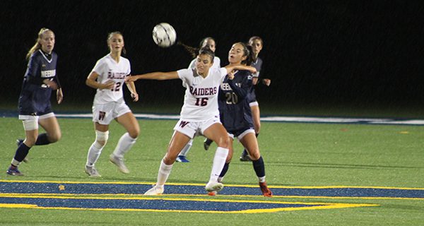 Wellesley’s Lilly DeOliveira (16) boxes out Needham’s Anda Gravlin (20) and gets set to cut up the field.