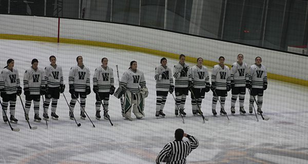 The Wolverines gather at center ice, right in front of the Bruins logo, to listen to the National Anthem. Photos by James Kinneen